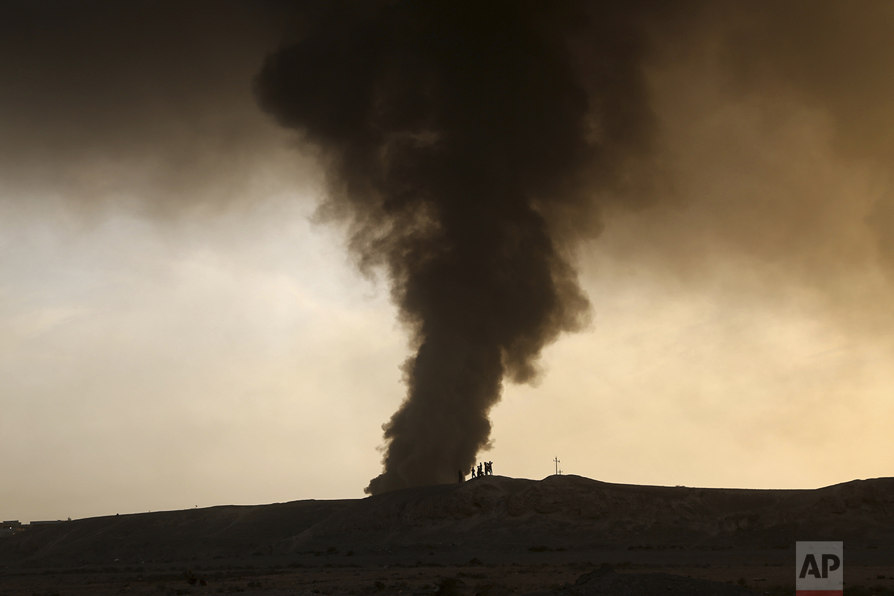 Smoke rises as people flee their homes during clashes between Iraqi security forces and members of the Islamic State group fleeing Mosul, Iraq, Tuesday, Oct. 18, 2016. The pace of operations slowed on Tuesday as Iraqi forces began pushing toward larger villages and encountering civilian populations on the second day of a massive operation to retake the northern Iraqi city of Mosul from the Islamic State group. (AP Photo)