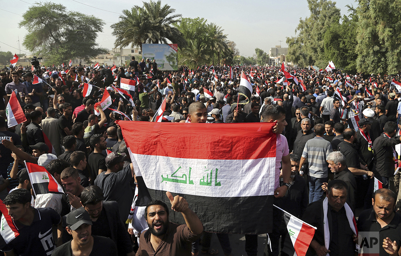Supporters of Shiite cleric Muqtada al-Sadr wave national flags during a demonstration in front of the Turkish Embassy calling for the immediate withdrawal of Turkish troops from northern Iraq, in Baghdad, Iraq, Tuesday, Oct. 18, 2016. Thousands of followers of al-Sadr are demanding the withdrawal of Turkish troops from a base near the northern city of Mosul. Turkey says the troops are training Iraqi fighters to help retake Mosul from the Islamic State group, and that they are there with the permission of the Iraqi government. Baghdad denies it granted permission and has ordered them to withdraw -- a call Ankara has ignored. (AP Photo/Karim Kadim)