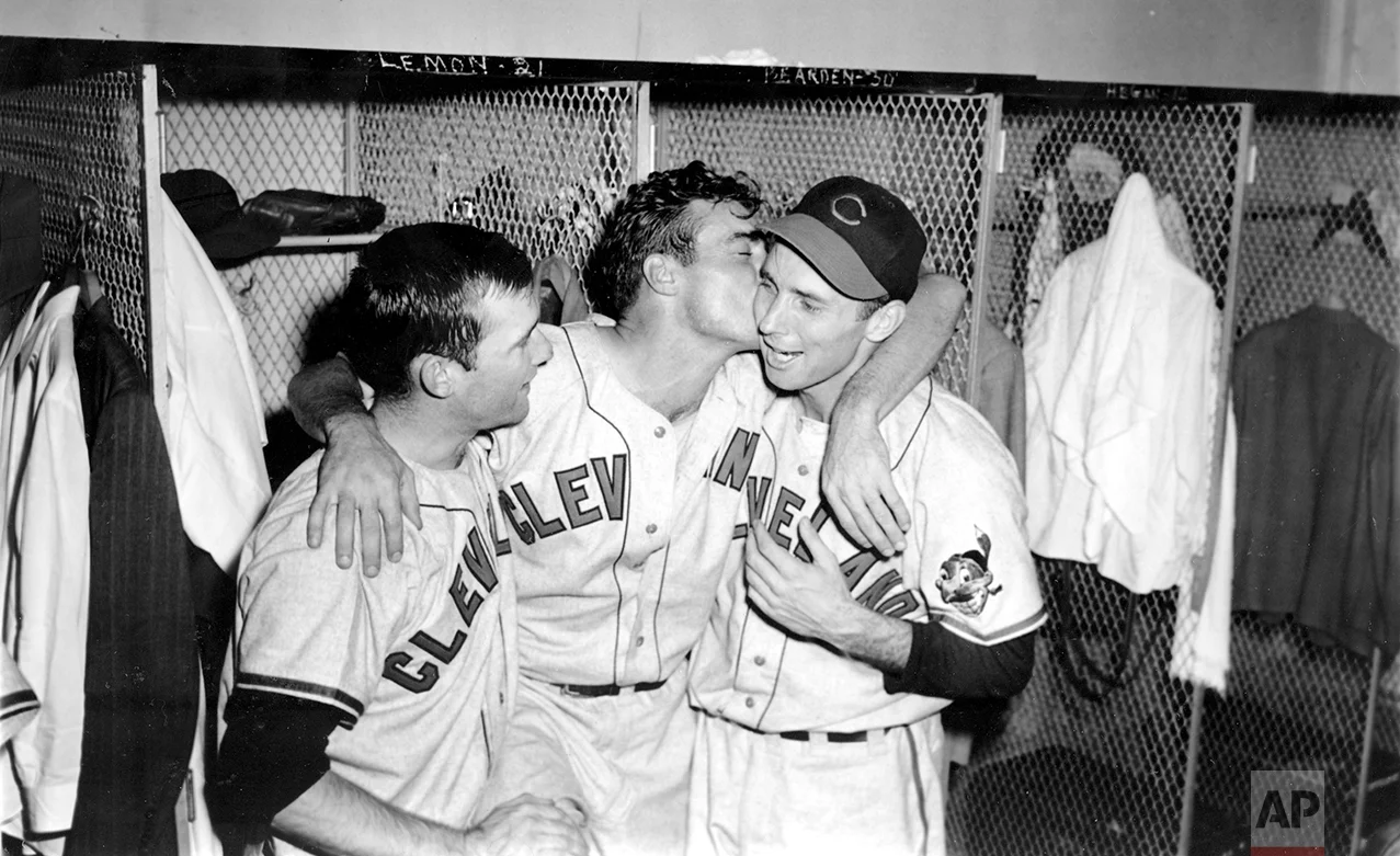 Cleveland Indians relief pitcher Gene Bearden, center, embraces his teammates starting pitcher Bob Lemon, left, and catcher Jim Hegan as they celebrate in the dressing room after winning the World Series in Boston, Ma., on Oct. 11, 1948. The Indians won 4-3 over the Boston Braves to clinch the 1948 World Series four games to two. (AP Photo)