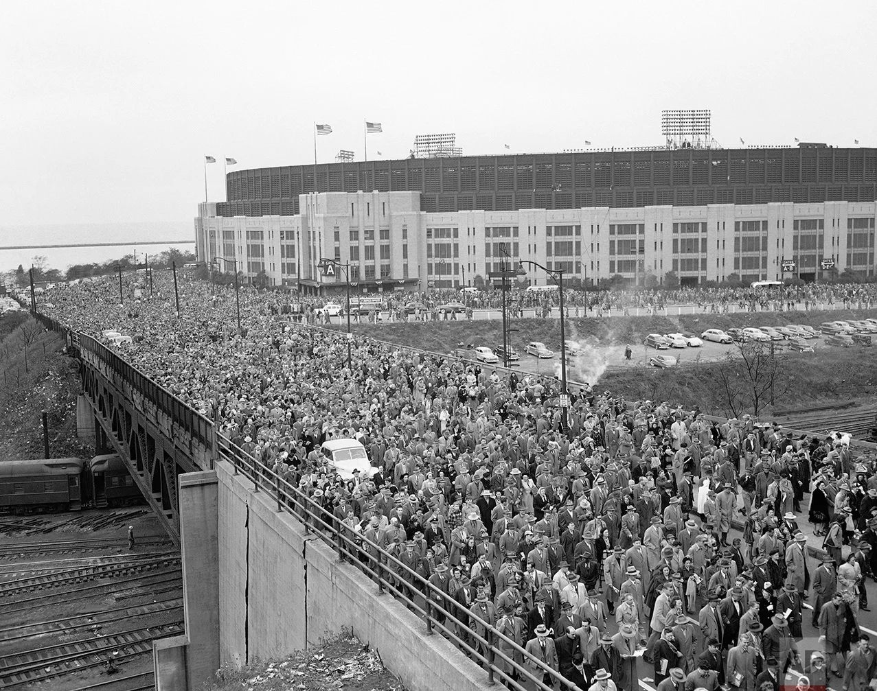 A crowd of 86,288 persons in Cleveland, OH, the largest ever in baseball history, makes its way across a railroad bridge from the Municipal Stadium after the fifth game of the 1948 World Series between the Cleveland Indians and Boston Braves on October 10, 1948, in Cleveland. Automobiles were lost in the mob. Boston won, 11-5. (AP Photo)