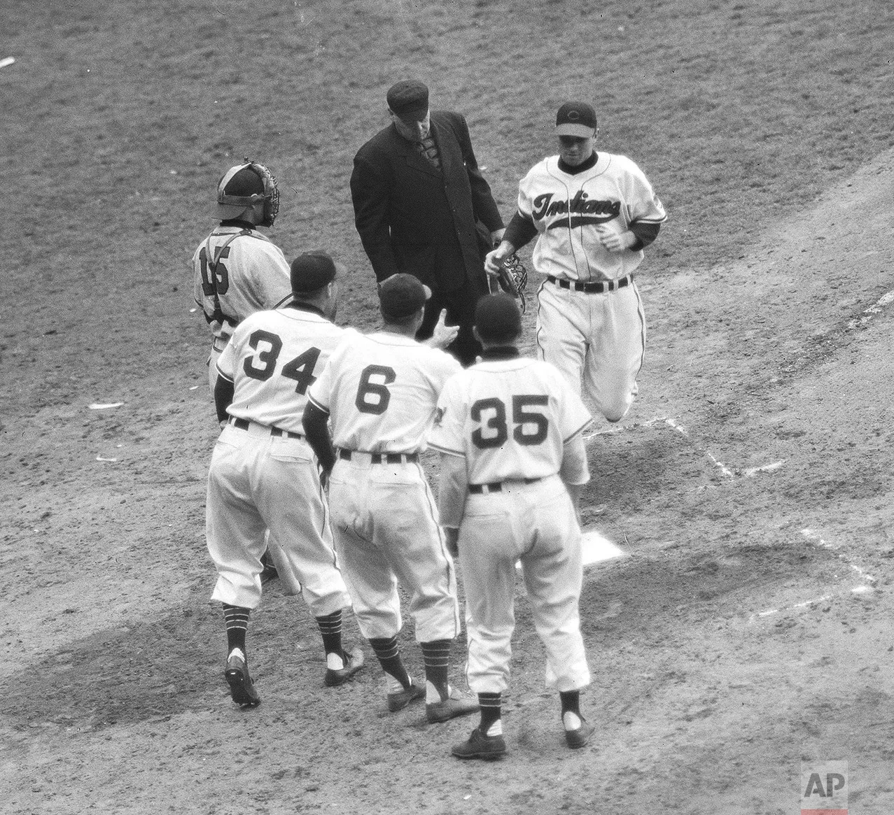 Indians crowd home plate to greet Jim Hegan, Cleveland catcher, scoring of his three-run home run in the fourth inning of the fifth World Series game in Cleveland, Oct. 10, 1948. Greeters are Dale Mitchell (34) Ken Keltner and Walt Judnich (35). Keltner and Judnich scored on the blow. Bill Salked (15) is Boston catcher and umpire is George Barr. (AP Photo)