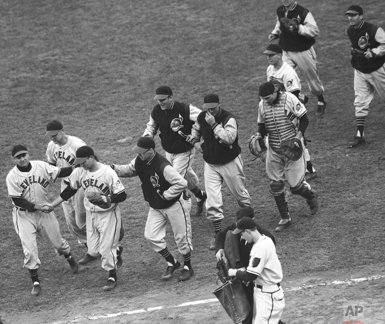 Phil Masi, Boston Braves catcher, clutches his cap as he crosses the plate to score the only run of the game in the World Series opener with the Cleveland Indians in Boston on Oct. 6, 1948. Masi scored from second on Tommy Holmes single to left field in the eighth inning of the game enabling the Braves to beat the Indians, 1-0. Watching Masi are Bob Feller (No.19), Indians pitcher, Alvin Dark, Braves shortstop, and Umpire George Barr. (AP Photo)