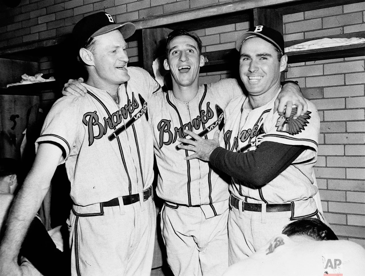 Winning pitcher Warren Spahn, center, of the Boston Braves is flanked by joyous teammates Bob Elliott, left, and Tommy Holmes in the dressing room in Cleveland, October 10, 1948, after an 11 to 5 win over Cleveland in the fifth World Series game. Spahn allowed only one hit in 5 and 2/3 innings of relief pitching. Elliott clouted two home runs. (AP Photo)
