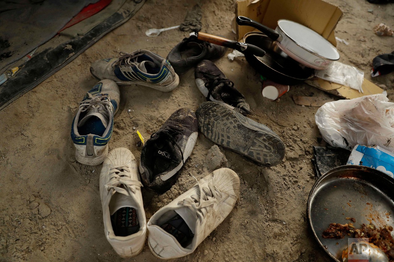 In this Wednesday, Oct. 26, 2016 photograph, shoes lay abandoned in the entranceway of a tent in the makeshift migrant camp known as "the jungle" near Calais, northern France. (AP Photo/Matt Dunham)