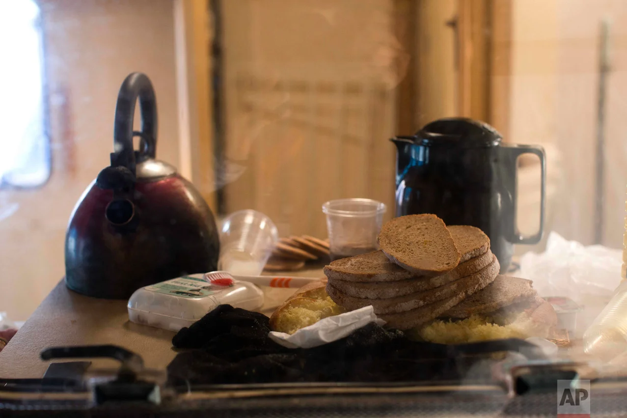 In this Thursday, Oct. 27, 2016 photo, bread and coffee is left behind by migrants in an abandoned caravan at the makeshift migrant camp known as "the jungle" near Calais, northern France. (AP Photo/Emilio Morenatti)