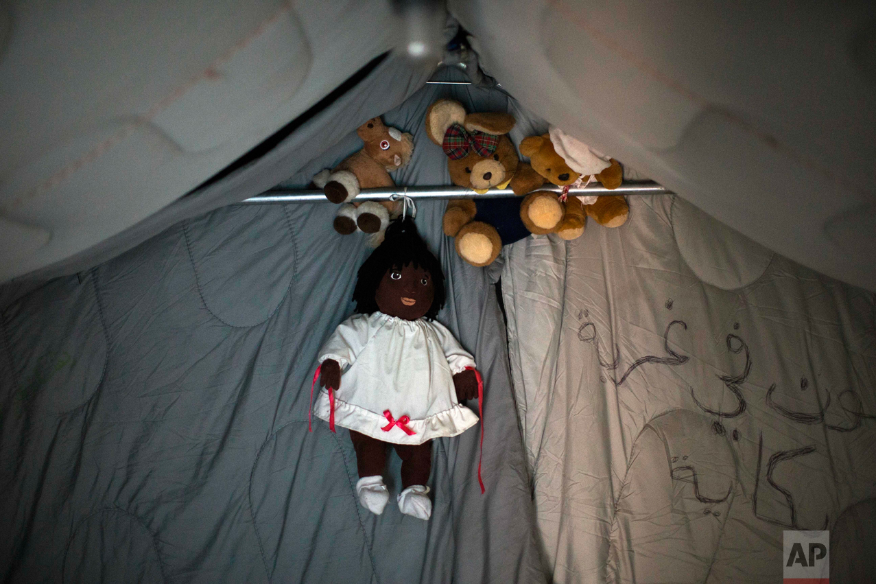 In this Tuesday, Oct. 25, 2016 photo, cuddly toys remain inside a tent let behind by their owners at the makeshift migrant camp known as "the jungle" near Calais, northern France. (AP Photo/Emilio Morenatti)
