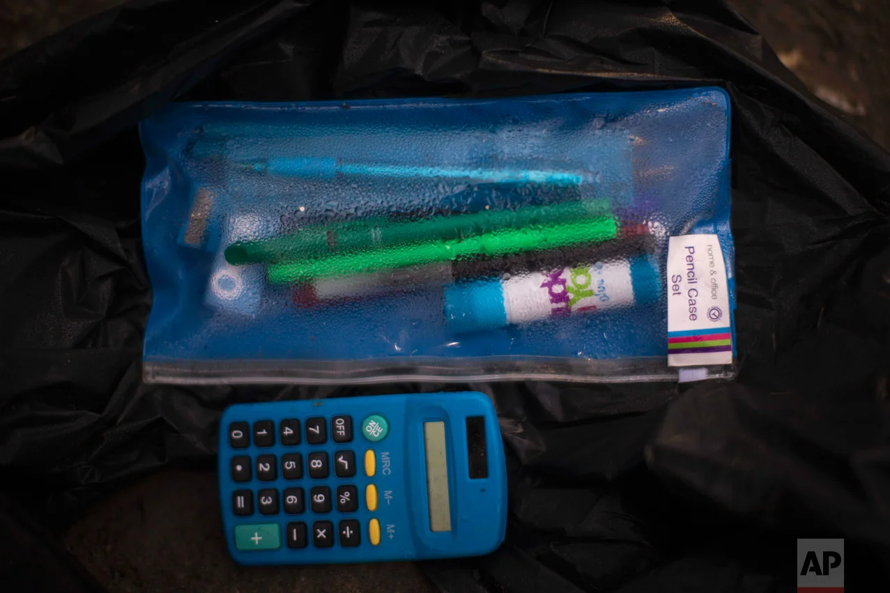 In this Thursday, Oct. 27, 2016 photo, a case containing pencils next to a calculator left behind by migrants in an abandoned tent at the makeshift migrant camp known as "the jungle" near Calais, northern France. (AP Photo/Emilio Morenatti)