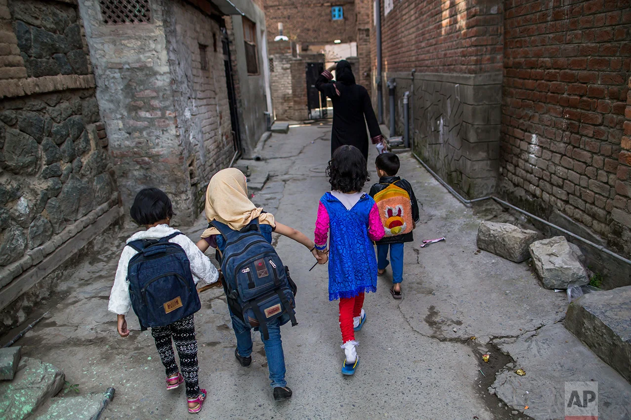 In this Friday, Oct. 7, 2016 photo, Kashmiri children walk home after attending an ad-hoc learning center set up in a community marriage hall in Srinagar, Indian controlled Kashmir. With daily life still paralyzed by strikes and rolling curfews, dozens of learning centers have popped up in people's homes or religious centers like mosques in Kashmir since August. The centers are doing more than just helping students prepare for upcoming exams, organizers said. They’re keeping kids off the streets and giving them comfort amid a civilian uprising sparked when a popular rebel leader was killed in fighting Indian forces on July 8. (AP Photo/Dar Yasin)