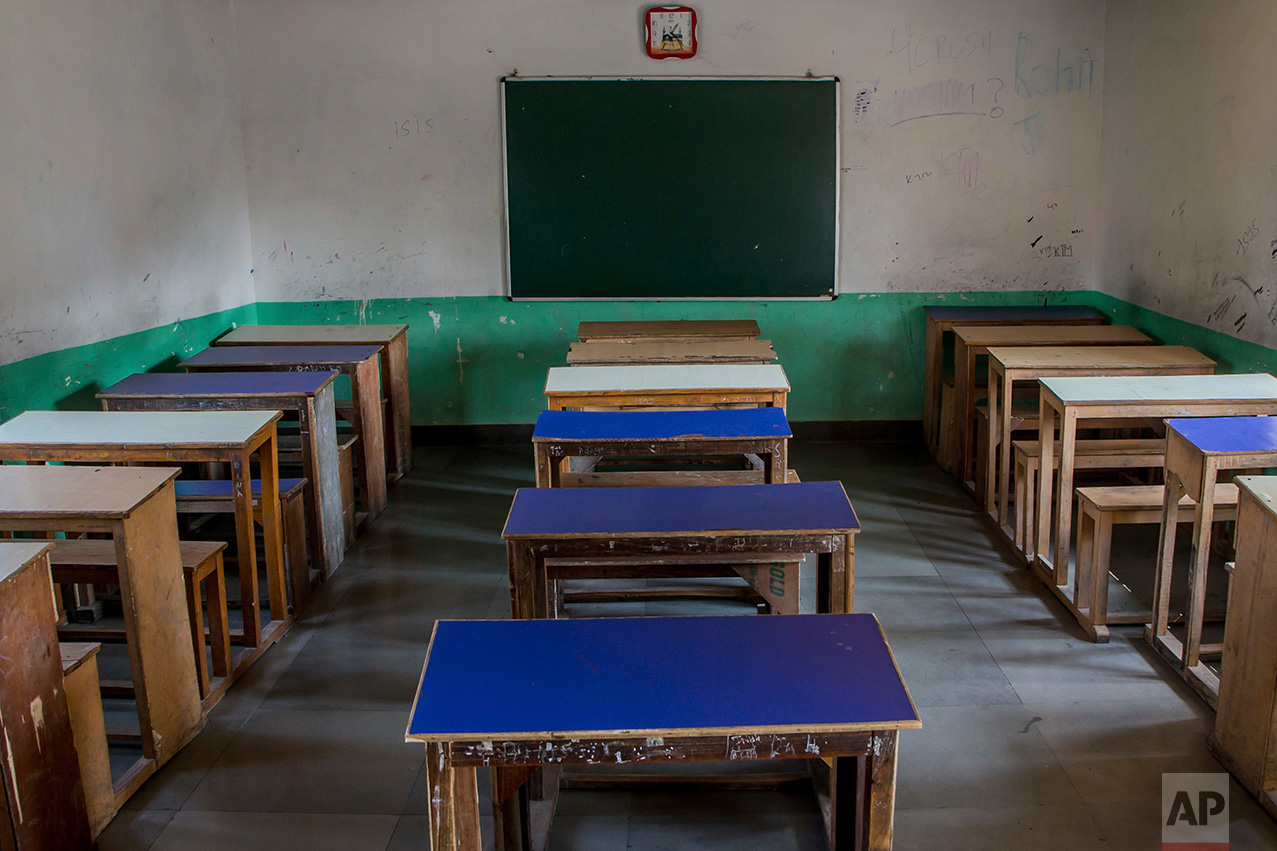 In this Tuesday, Oct. 18, 2016 photo, desks and benches stand in a row inside an empty classroom of a private school that has remained closed for the past three months in Srinagar, Indian controlled Kashmir. With daily life still paralyzed by strikes and rolling curfews, dozens of ad-hoc learning centers have popped up in people's homes or religious centers like mosques in Kashmir since August. The centers are doing more than just helping students prepare for upcoming exams, organizers said. They're keeping kids off the streets and giving them comfort amid a civilian uprising sparked when a popular rebel leader was killed in fighting Indian forces on July 8. (AP Photo/Dar Yasin)