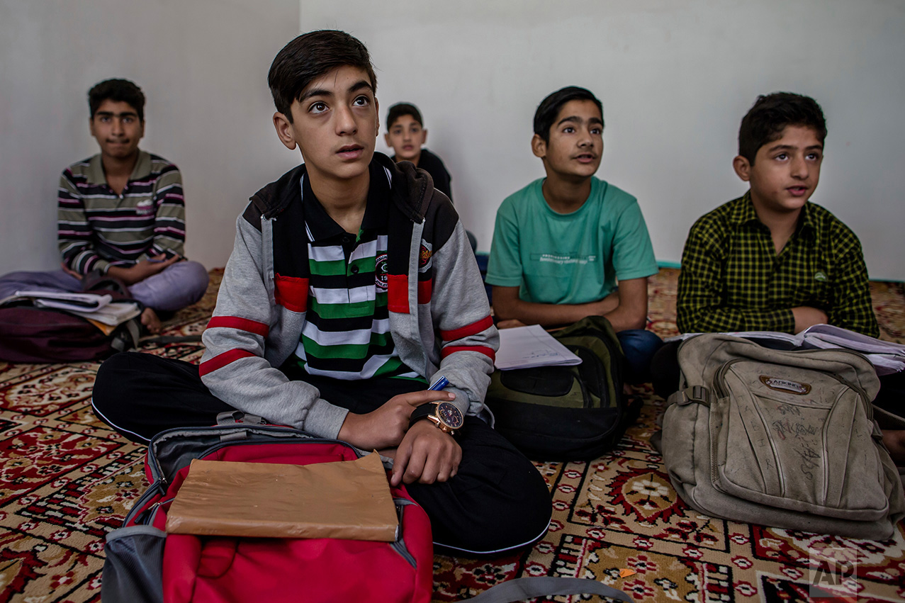 In this Thursday, Oct. 6, 2016 photo, Kashmiri boys study in an ad-hoc learning center set up in a community hall in Srinagar, Indian controlled Kashmir. With daily life still paralyzed by strikes and rolling curfews, dozens of learning centers have popped up in people's homes or religious centers like mosques in Kashmir since August. The centers are doing more than just helping students prepare for upcoming exams, organizers said. They’re keeping kids off the streets and giving them comfort amid a civilian uprising sparked when a popular rebel leader was killed in fighting Indian forces on July 8. (AP Photo/Dar Yasin)