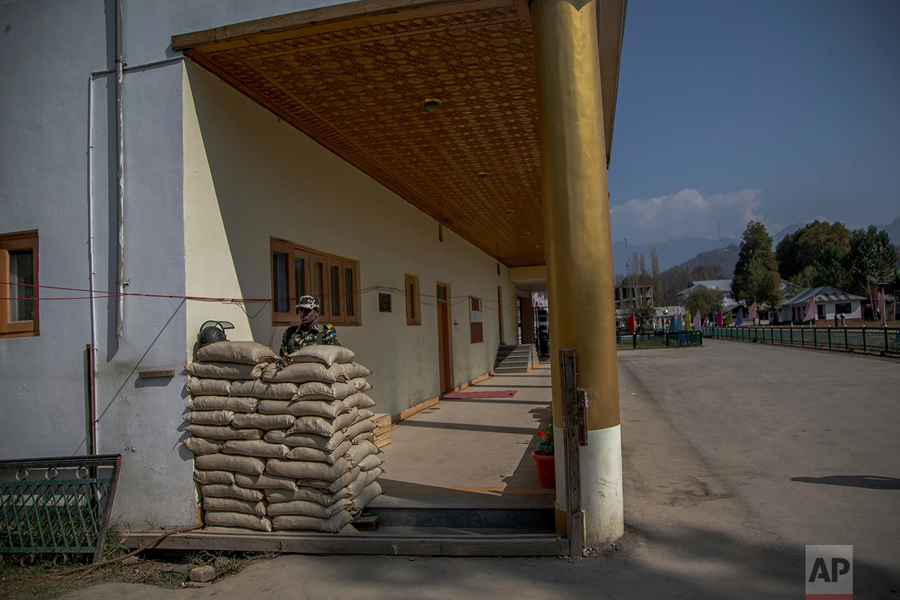 In this Friday, Oct. 21, 2016 photo, a paramilitary soldier keeps vigil inside the Government Girls Higher Secondary Institute after it was converted into a paramilitary bunker in Srinagar, Indian controlled Kashmir. Kashmir has been under a tight security lockdown, along with a separatist-sponsored strike, as Indian forces struggle to quell the uprising and arrest thousands of civilian protesters. The region, also claimed by Pakistan, is divided between the two nuclear-armed neighbors by a heavily militarized Line of Control. (AP Photo/Dar Yasin)