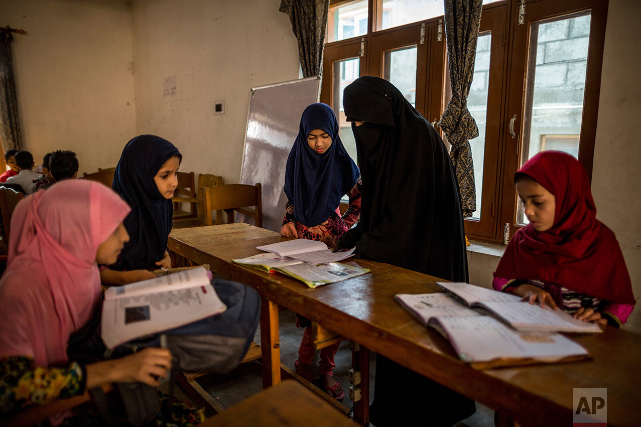 In this Friday, Oct. 7, 2016 photo, Kashmiri girls study in an ad-hoc learning center set up in a community marriage hall in Srinagar, Indian controlled Kashmir. With daily life still paralyzed by strikes and rolling curfews, dozens of learning centers have popped up in people's homes or religious centers like mosques in Kashmir since August. The centers are doing more than just helping students prepare for upcoming exams, organizers said. They're keeping kids off the streets and giving them comfort amid a civilian uprising sparked when a popular rebel leader was killed in fighting Indian forces on July 8. (AP Photo/Dar Yasin)