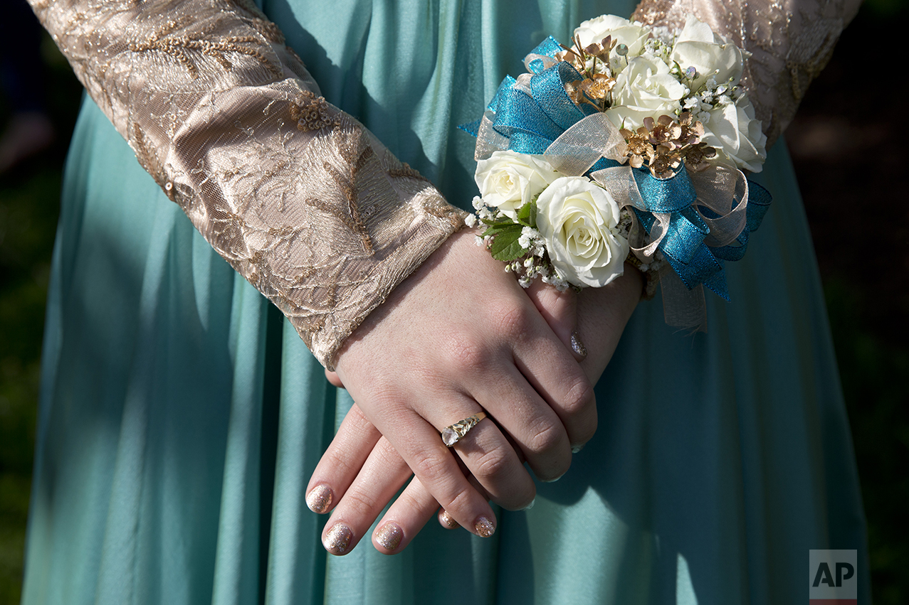 Nails freshly manicured Hannah Shraim, 17, wears a wrist corsage as she meets her friends before they left to attend their senior prom, in Germantown, Md., Friday, May 13, 2016. (AP Photo/Jacquelyn Martin)