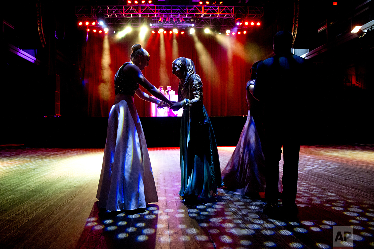 Samantha Bischoff, left, compliments Hannah Shraim on her prom dress during Northwest High School's senior prom at the Fillmore Theater in Silver Spring, Md., on Friday, May 13, 2016. (AP Photo/Jacquelyn Martin)