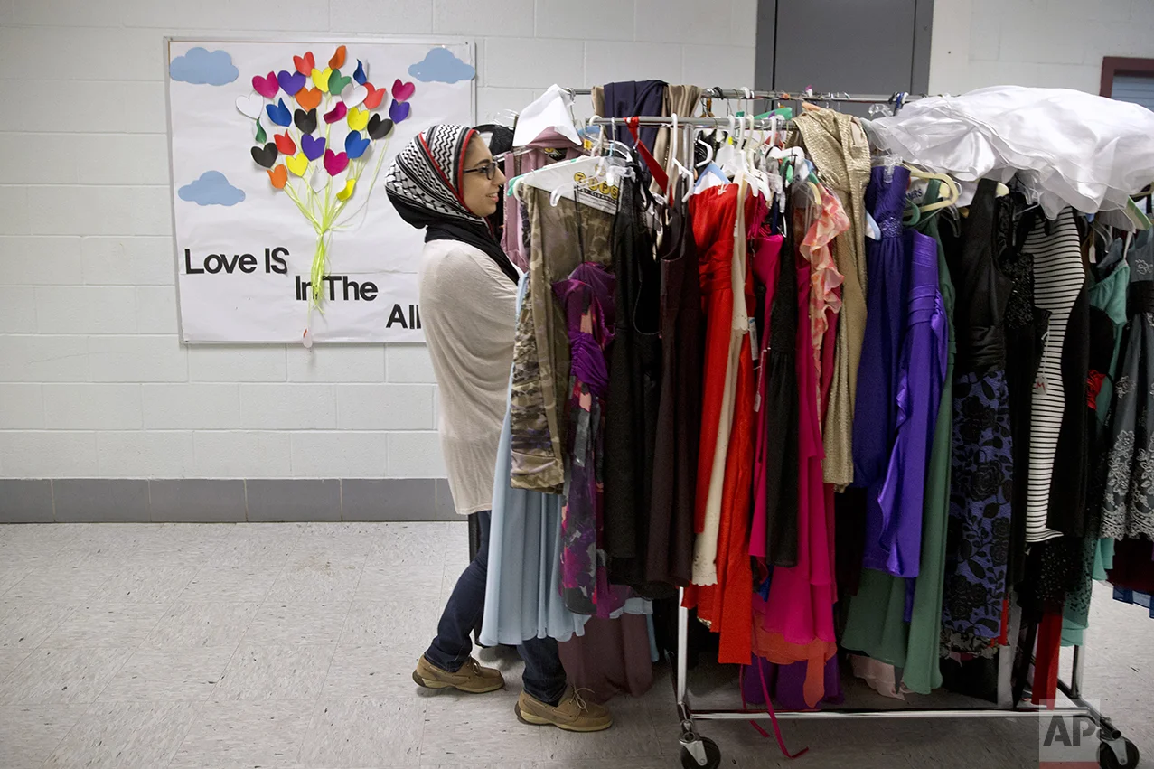 Hannah Shraim, 17, helps to move prom dresses for a fundraiser at Northwest High School in Germantown, Md., Tuesday, May 10, 2016. (AP Photo/Jacquelyn Martin)