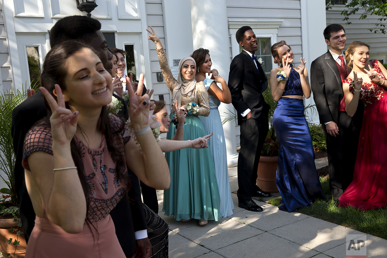 Hannah Shraim, center, playfully poses with Ashley Riddle, right, as their prom group poses for a "fun" photograph for their parents in Germantown, Md., before attending their senior prom for Northwest High School, Friday, May 13, 2016. Shraim and Riddle both went to prom solo while the others in the group brought dates. Shraim ordered her prom dress from a Turkish website that specializes in modest fashion. (AP Photo/Jacquelyn Martin)