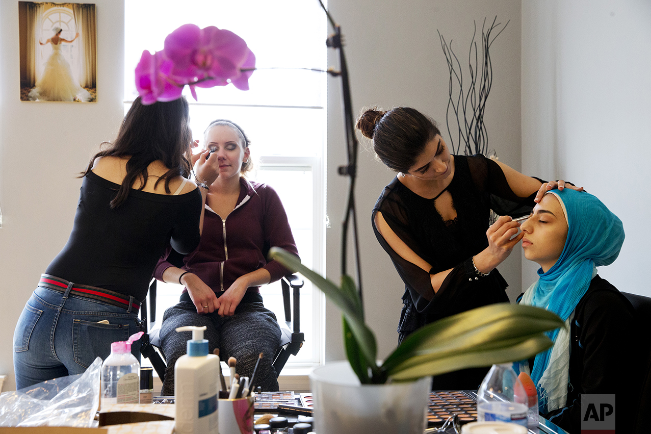Hannah Shraim, 17, right, and Hannah Reid, 18, left, have their makeup applied as they prepare to attend Northwest High School's senior prom, in Germantown, Md., on Friday, May 13, 2016. (AP Photo/Jacquelyn Martin)