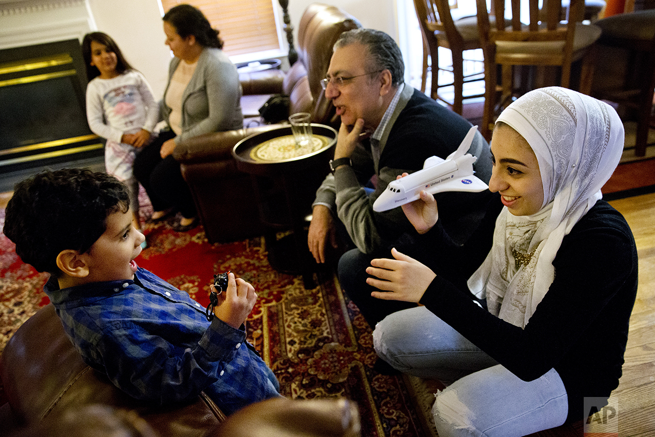 Hannah Shraim, 17, right, plays with Karim Algamil, 5, next to her father Ihab Shraim, at the Shraim family home in Germantown, Md., Friday, May 6, 2016. (AP Photo/Jacquelyn Martin)