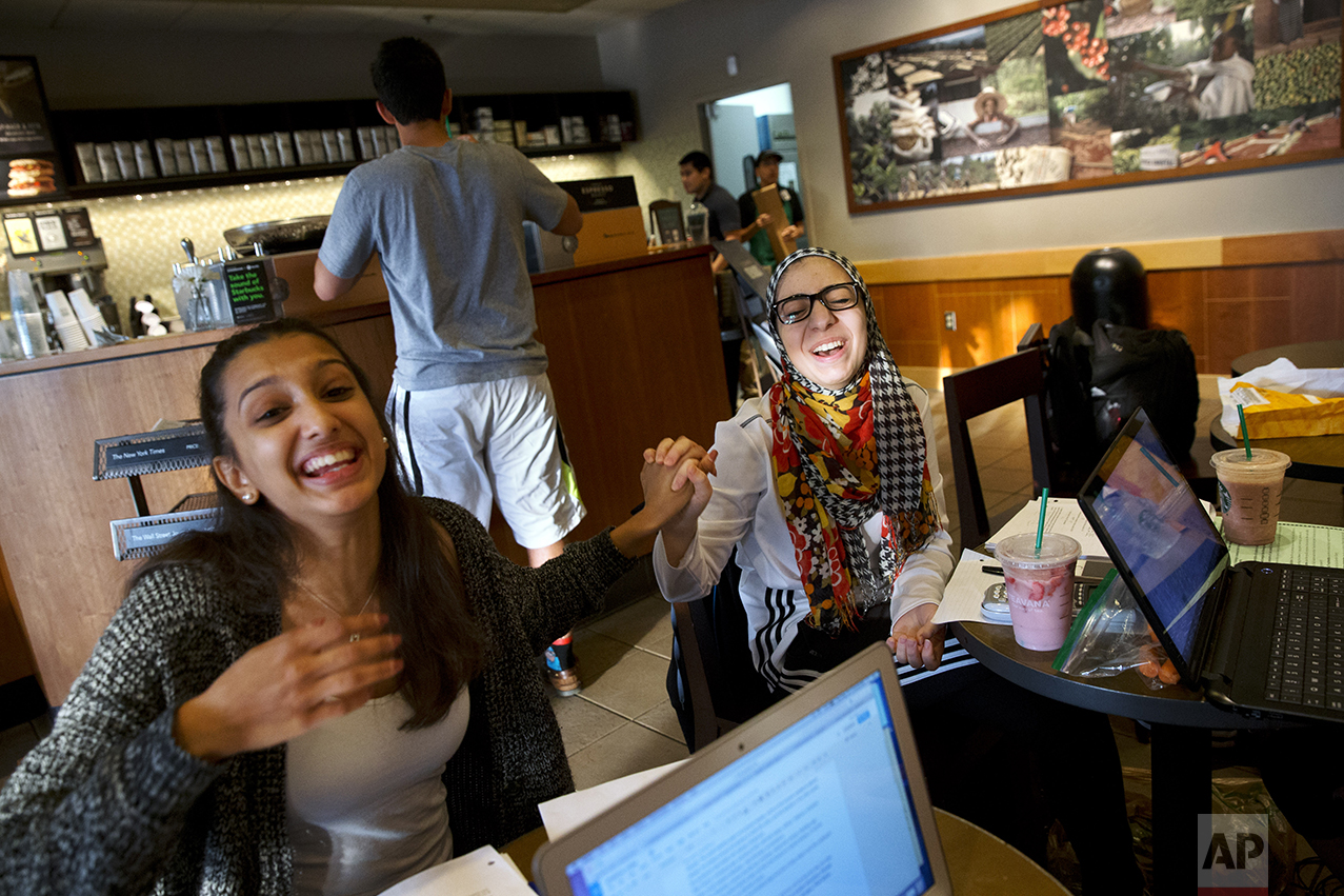 Hannah Shraim, 17, right, jokes with Mekhala Rao, 17, while studying for their final exams at a Starbucks in Germantown, Md., Tuesday, May 10, 2016. (AP Photo/Jacquelyn Martin)