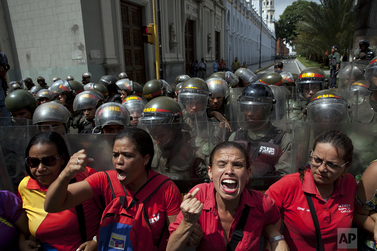 Supporters of Venezuela's President Nicolas Maduro chant pro-government slogans outside the National Assembly where the opposition-led legislature is debating his removal, in Caracas, Venezuela, Thursday, Oct. 27, 2016. Electoral authorities blocked a recall campaign against Maduro the previous week, and the face-off escalated on Tuesday when the legislature voted to put Maduro on trial, accusing him of effectively staging a coup. (AP Photo/Rodrigo Abd)