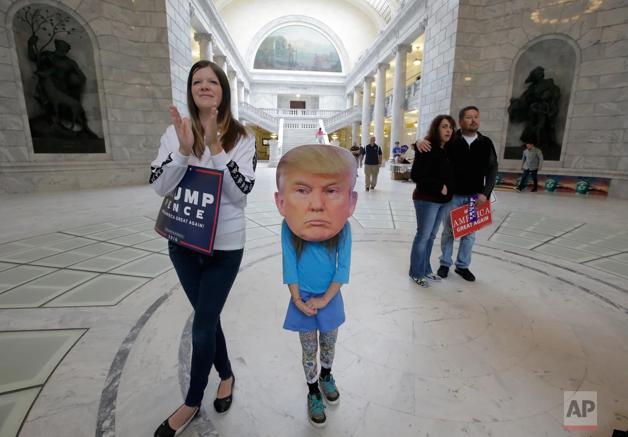 Trump supporters Gabriella Morris, 7, center, looks on with her mother Anne Morris, left, during a rally for Donald Trump Tuesday, Nov. 1, 2016, at the Utah State Capitol in Salt Lake City. Some of Utah's top Republicans are urging their fellow conservatives to unite around Donald Trump as the billionaire candidate's lead in the solidly red state has fallen. (AP Photo/Rick Bowmer)