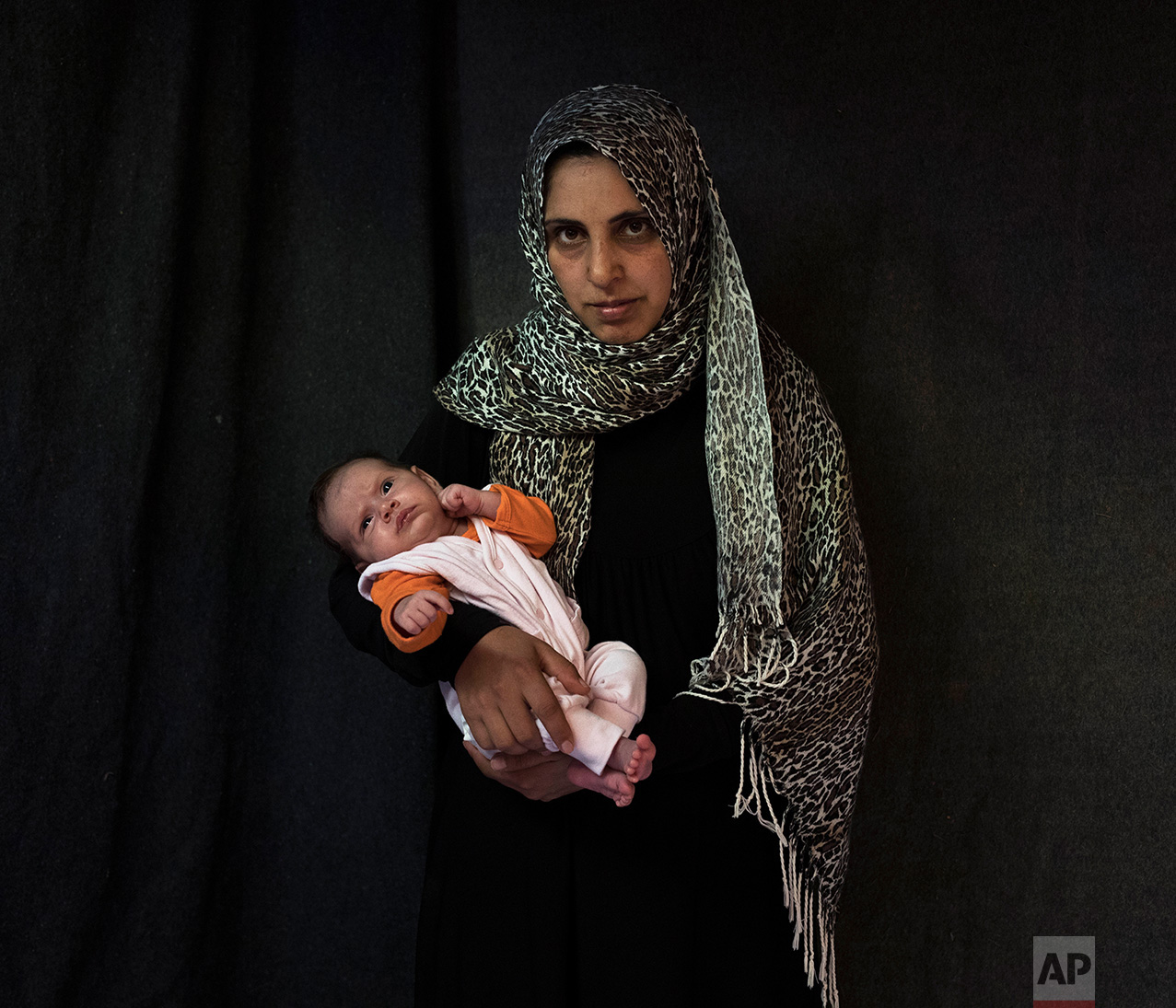  In this Tuesday Sept. 13, 2016 photo 35-year-old Siha Hamnad, a Syrian mother from Al Qunaytirah, poses with her baby girl Mona Alzaour in a tent made of blankets given by UNCHR at the Ritsona refugee camp in Greece. Siha is one of the hundreds of r