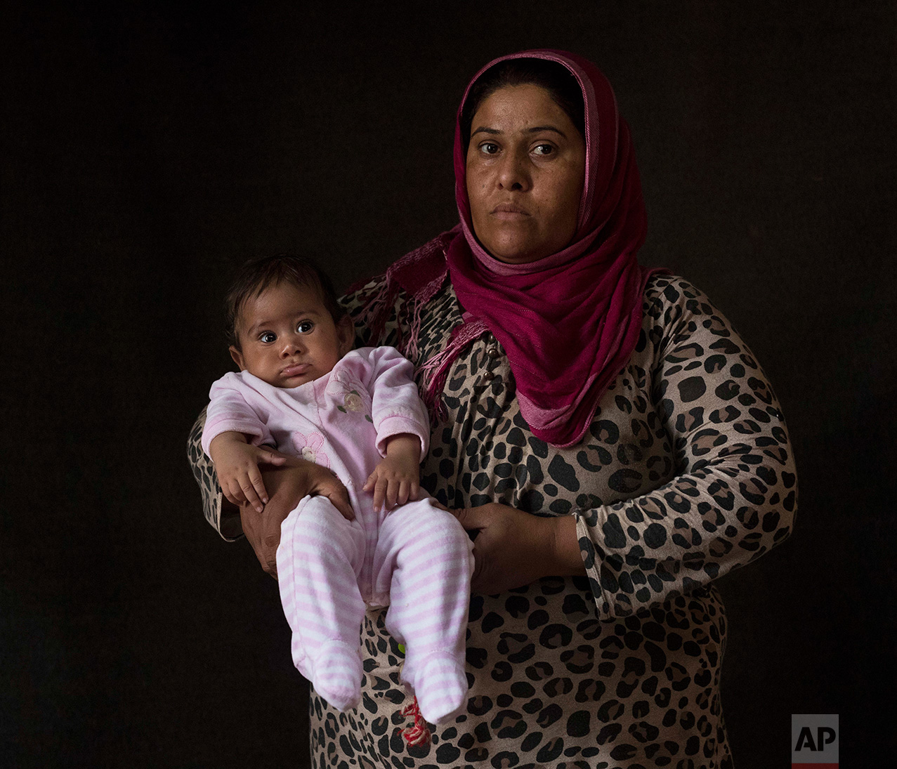  In this Thursday Sept. 22, 2016 photo 35-year-old Najlaa Khalil Tamo, a Syrian mother from Al Hasakah, poses with her baby girl Ritsona Khalil Isa, in a tent made of blankets given by UNCHR at the Ritsona refugee camp in Greece. Najlaa is one of the