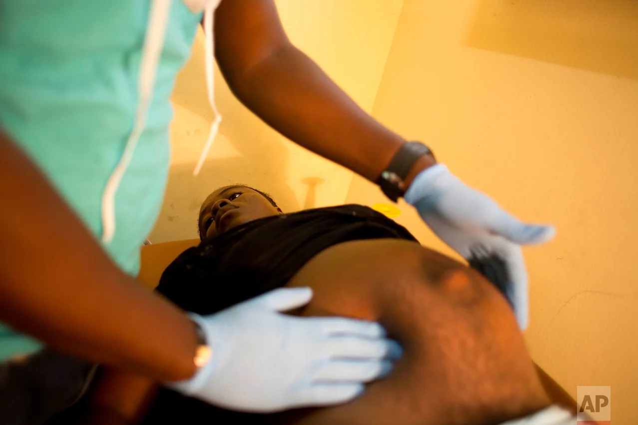 In this Nov. 1, 2016 photo, Nathanaelle Bernard, who is 7 months pregnant, undergoes a prenatal checkup at the state hospital in Port-Salut, a town near Coteaux, Haiti. In Coteaux, Nathanaelle occasionally gets shooting pains in her stomach, retreating to a bed in the shack her uncle built from scavenged materials after the family's home was destroyed. (AP Photo/Dieu Nalio Chery)