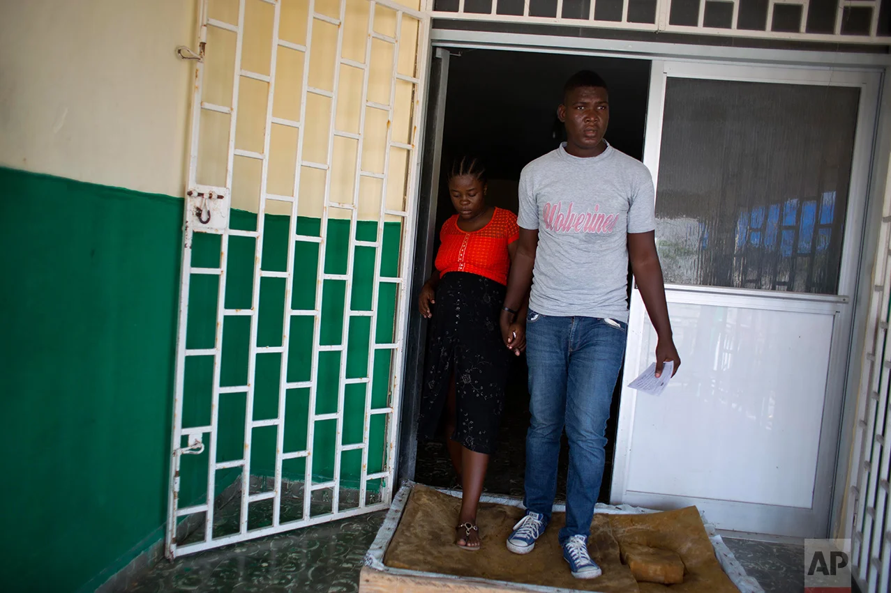 In this Nov. 1, 2016 photo, Nathanaelle Bernard, who is 7 months pregnant, and her boyfriend Romual Saint Jean, leave the state hospital, after her prenatal checkup, in Port-Salut, a town near Coteaux, Haiti, where the couple live. Saint-Jean, the 27-year-old father of her unborn child, moved Bernard to her uncle's coastal village from Port-au-Prince after she contracted typhoid in early 2016. They believed Coteaux's salt air and slow-paced life would do her good. (AP Photo/Dieu Nalio Chery)