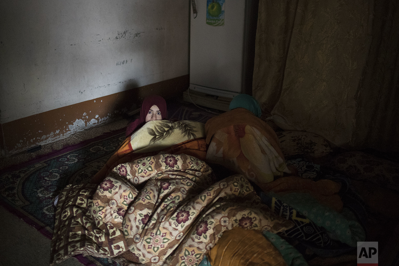  A girl hides behind a blanket as Iraqi special forces enter her house while advancing towards Islamic State militant-held territory in Mosul, Iraq, Friday, Nov. 18, 2016. (AP Photo/Felipe Dana) 