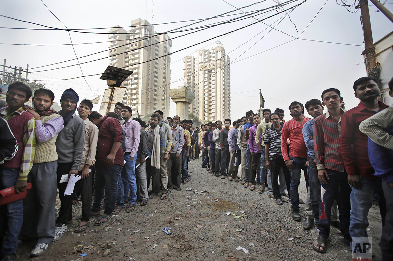 People stand in lines outside a bank to exchange or deposit discontinued currency notes in New Delhi, India, Tuesday, Nov. 15, 2016. India's government said Tuesday that it will mark the fingers of people swapping scrapped currency notes at banks with indelible ink as authorities struggle to deal with the corruption and bedlam spawned by the demonetizing of the country's highest denomination currency. (AP Photo/Altaf Qadri)