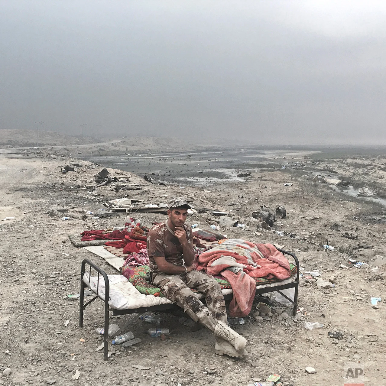 In this photo taken Wednesday, Oct. 26, 2016, Alaa Hashid, from Shura, Iraq, an Iraqi army soldier, poses for a portrait at a checkpoint in Qayara, some 50 kilometers south of Mosul, Iraq. The push to kick the Islamic State out of Mosul has brought together an eclectic mix of Iraqis, young and old, police and soldiers, and a variety of irregular uniforms and equipment. (AP Photo/Marko Drobnjakovic)