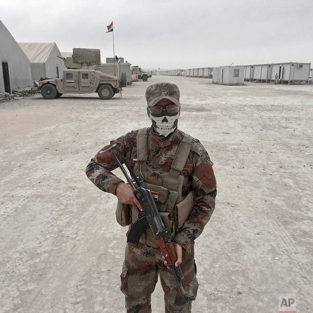In this photo taken Friday, Oct. 28, 2016, Loay Mahdi, from Kirkuk, an Iraqi army soldier, poses for a portrait at the Qayara West Coalition base in Qayara, some 50 kilometers south of Mosul, Iraq. The push to kick the Islamic State out of Mosul has brought together an eclectic mix of Iraqis, young and old, police and soldiers, and a variety of irregular uniforms and equipment. (AP Photo/Marko Drobnjakovic)