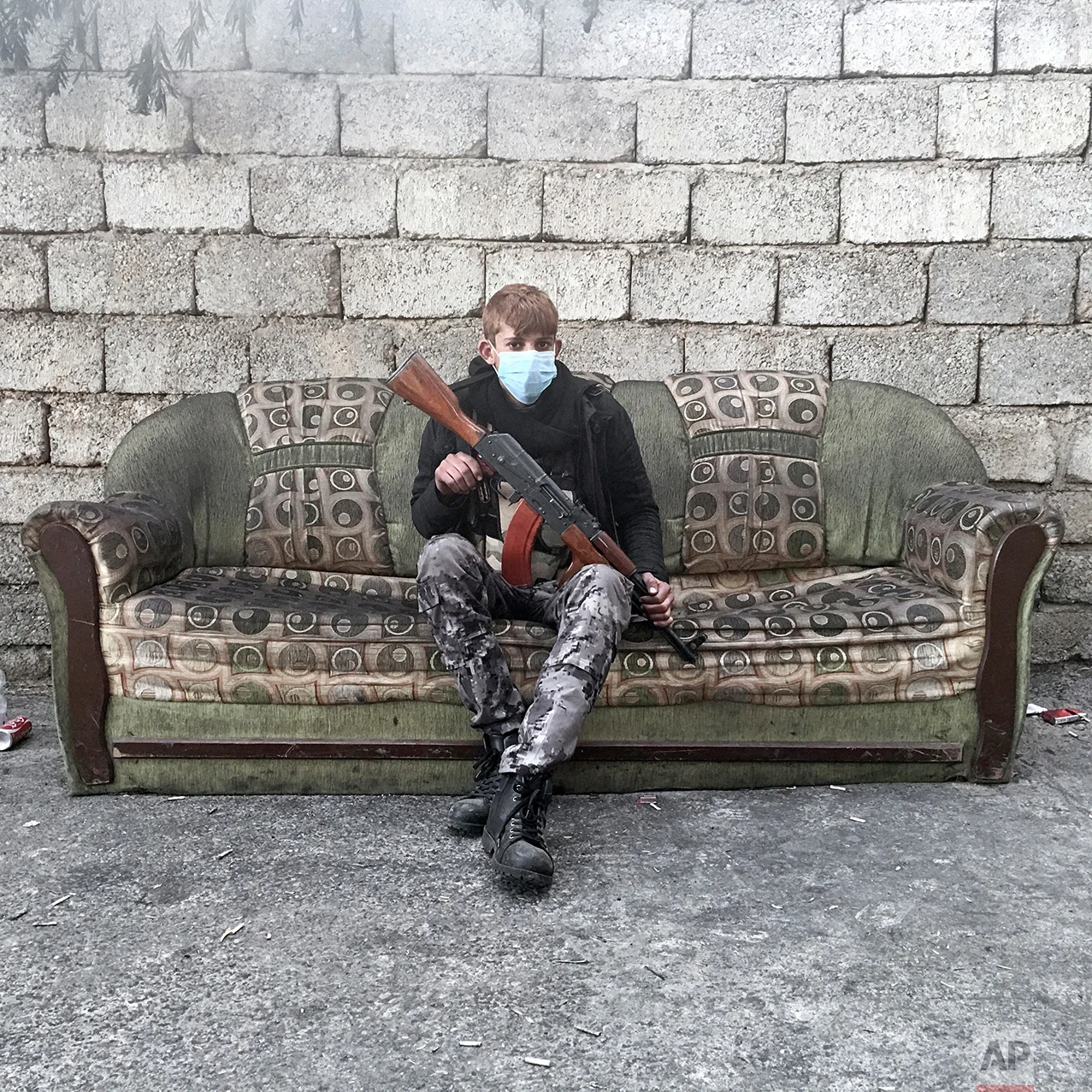 In this photo taken Thursday, Nov. 10, 2016, Abdelhakim Hamid, 19, from Qayara, Iraq, an Iraqi National Security armed guard, poses for a portrait in Qayara, some 50 kilometers south of Mosul, Iraq. The push to kick the Islamic State out of Mosul has brought together an eclectic mix of Iraqis, young and old, police and soldiers, and a variety of irregular uniforms and equipment. (AP Photo/Marko Drobnjakovic)