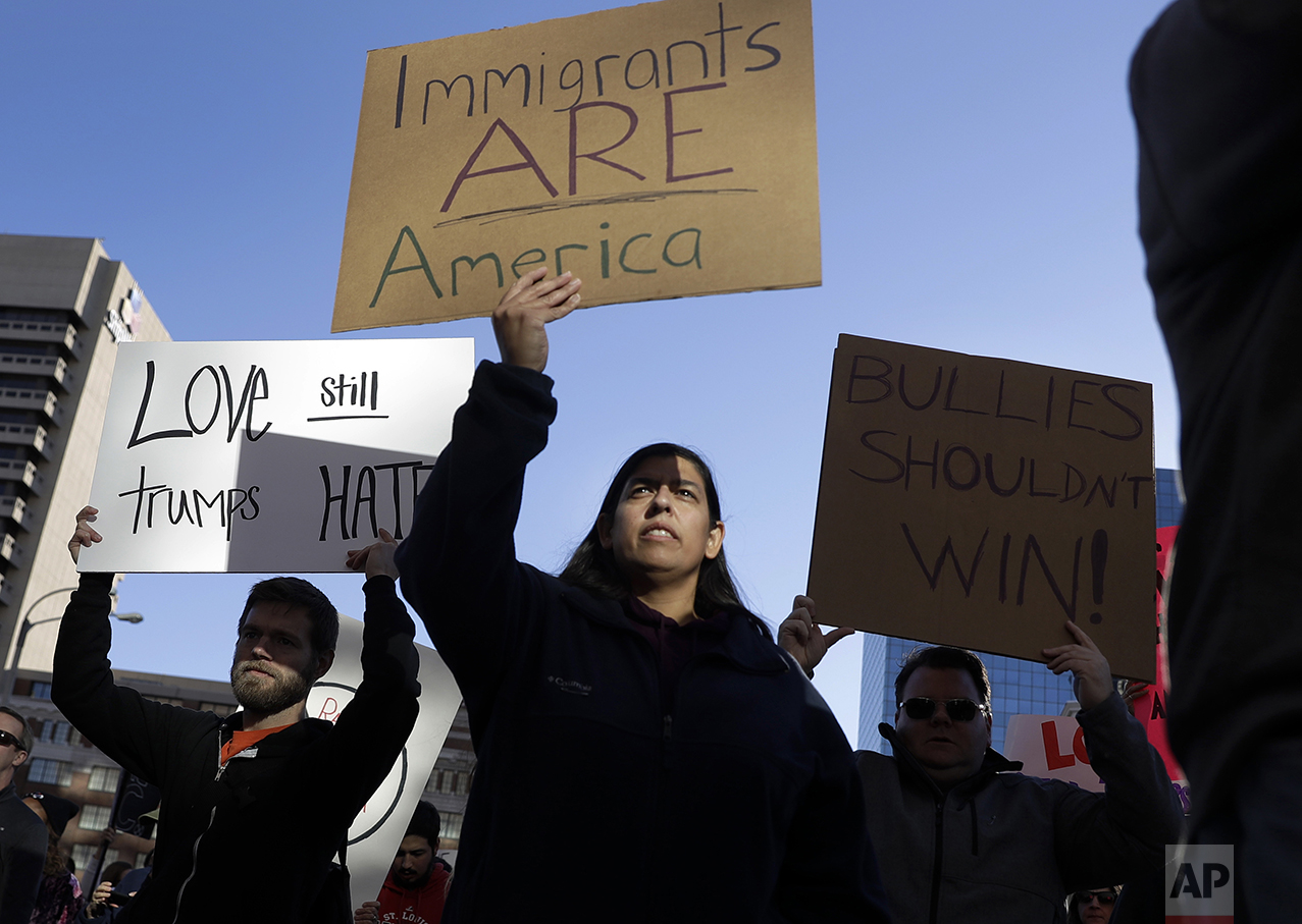 Protesters hold signs as they march in opposition to the election of President-elect Donald Trump on Sunday, Nov. 13, 2016, in St. Louis. (AP Photo/Jeff Roberson)