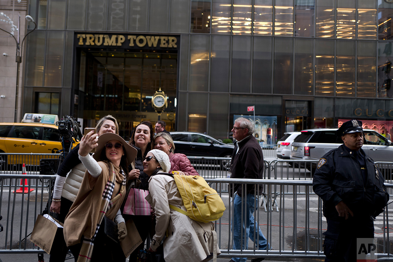 In this Wednesday, Nov. 16, 2016 photo, a group of women pose for a selfie outside Trump Tower in New York. (AP Photo/Muhammed Muheisen)