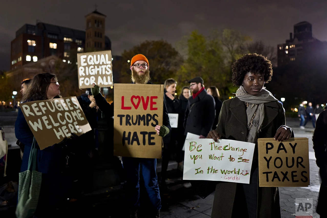 In this Tuesday, Nov. 15, 2016 photo, protestors hold banners during a protest against President-elect Donald Trump in Washington Square Park in New York. (AP Photo/Muhammed Muheisen)