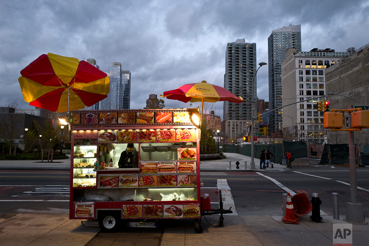 In this Sunday, Nov. 20, 2016 photo, a food vendor waits for customers on a roadside in New York. (AP Photo/Muhammed Muheisen)