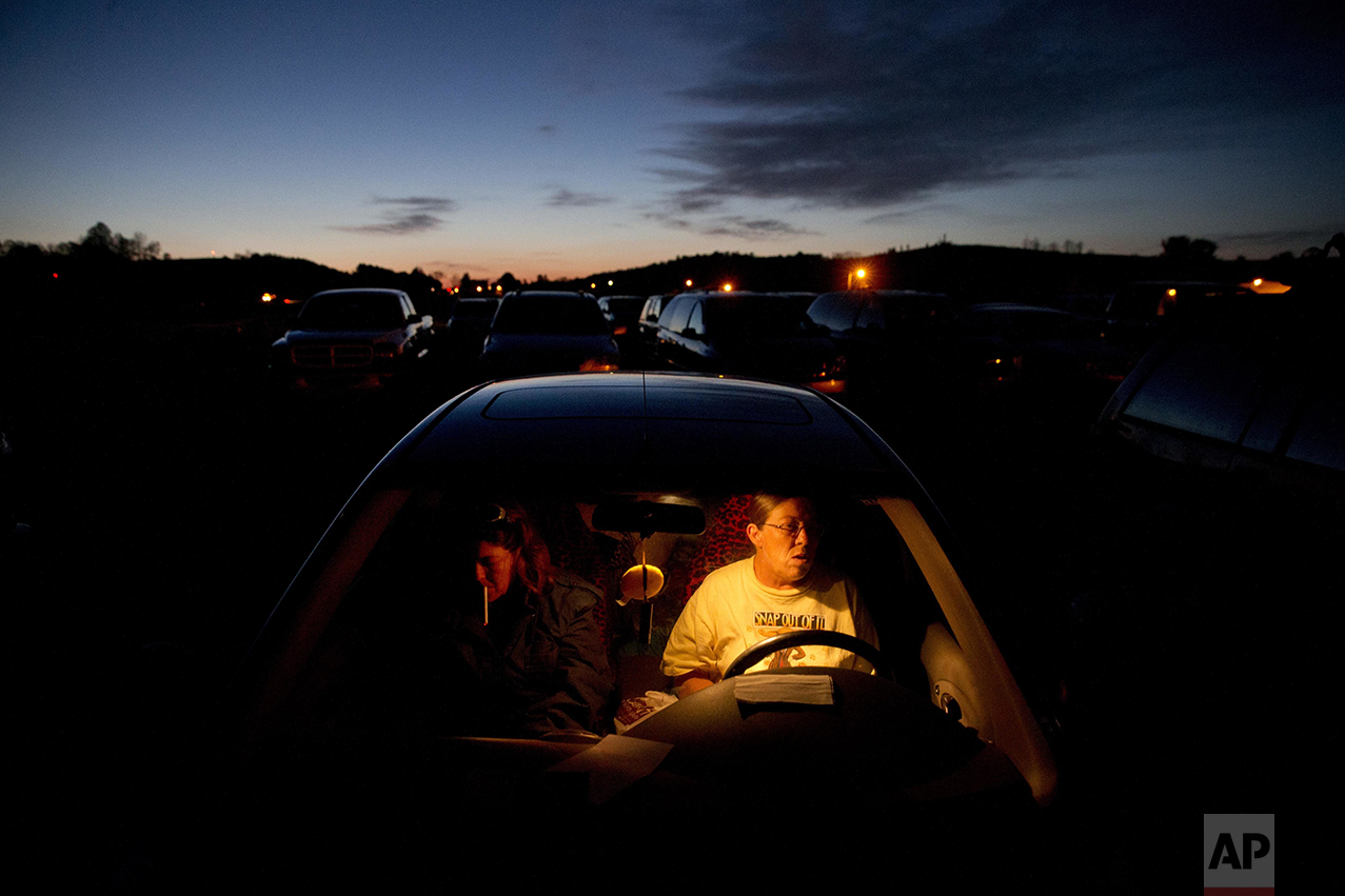 Lesia Crigger, 47, left, of Woodlawn, Va., who is hoping to get fitted for dentures, lights a cigarette while waiting with her sister, Rhonda Gravley, 52, of Galax, Va., in a car overnight for the opening of the Remote Area Medical event at dawn Friday, April 29, 2016 in Smyth County, Va. Hundreds of others also waited overnight. Gravley, who is attending for the first time, is also hoping to go the dental clinic. Neither have dental insurance and cannot afford to pay for it on their own. "I want all of my teeth pulled," says Gravley, "they're all hurting me." She ended up having several pulled by volunteer dentist Mark Copas. "I've done foreign volunteer missions before," says Copas, "but never domestic. These cases are just as bad as what I've seen in third world countries." RAM provides free medical care to people in isolated and poverty stricken communities who do not have health insurance, in several states across the U.S. (AP Photo/Jacquelyn Martin)