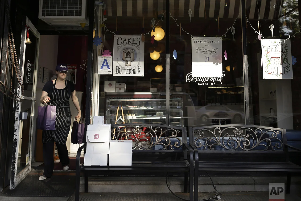 Buttermilk Bakeshop owner Katie Rosenhouse carries a wholesale order to a customer at her bakery, Wednesday, May 11, 2016 in the Brooklyn borough of New York. Rosenhouse employs 14 hourly workers both full and part time for two bakeshops in the Park Slope neighborhood. While she understands that the minimum wage needs to be raised, she feels $15 is too high for a small business owner and the raise would affect the price of her product and also cut the number of people she can employ. "Small bakeries can't afford to pay people that much... That's a lot of money when you're selling cupcakes. That's a lot of cupcakes," she says. "It's great to pay people well when you're in business, but if you're out of business no one is making anything." (AP Photo/Julie Jacobson)