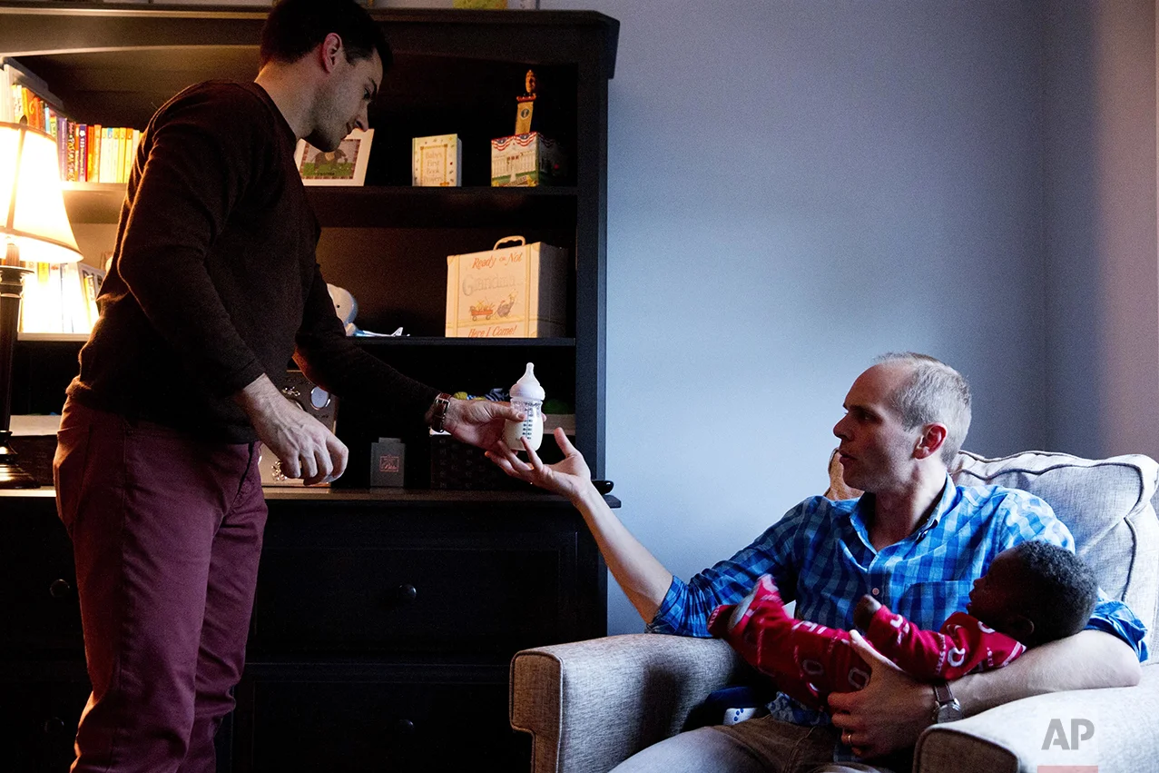 Brooks Brunson, left, passes a bottle of formula to his husband, Gregg Pitts, as they prepare their son, Thomas Brunson-Pitts, 6-months old, for bed at their home in Washington on Wednesday, May 4, 2016. Originally from Texas and Ohio, they were married in the District of Columbia in November 2013. Brunson and Pitts always knew they wanted to have a family together, and were delighted when they were able to start the adoption process for their son shortly after beginning to look for a match in 2015. Although it's an open adoption, the mother has chosen not to be involved in her child's life and had no problem with a same sex couple adopting her son. "We're an interracial same sex couple family," says Brunson, "But our day-to-day life is picking up dry cleaning, getting to work on time, making sure Thomas has his bottle prepared - we're the most boring people I know. But then when I take a step back I realize we are very unique. But I believe this is exactly where God wants me to be." The District of Columbia legalized gay marriage in 2010. (AP Photo/Jacquelyn Martin)