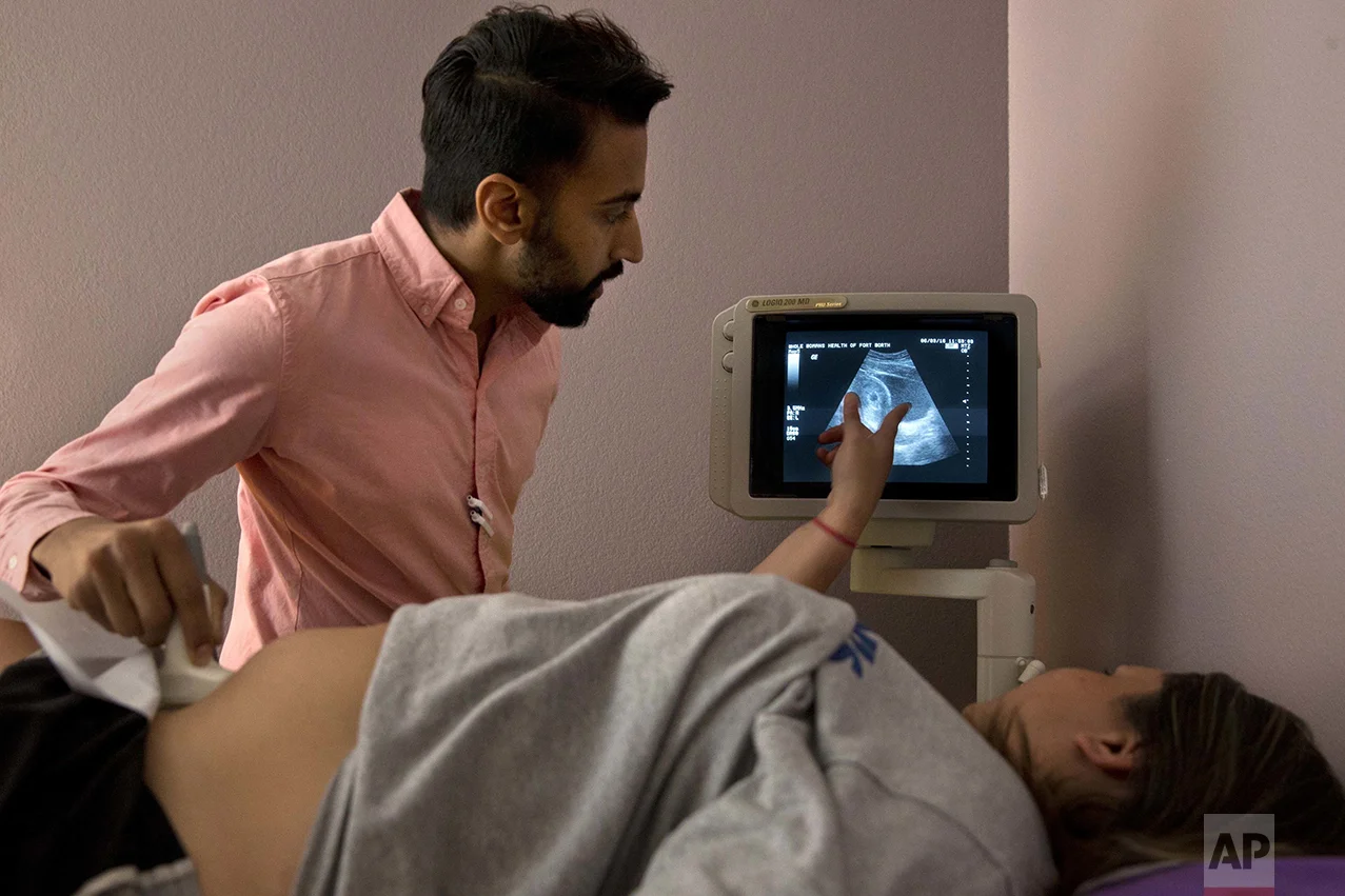 Dr. Bhavik Kumar, 31, listens to a question from a patient considering abortion during her ultrasound at the Whole Woman's Health clinic in Fort Worth, Texas, on Friday, June 3, 2016. Women considering abortion are required by the state to have a sonogram that they must be offered the chance to view, although they can refuse to look. There is then a required 24-hour waiting period after the initial consultation. Some must now travel long distances twice in order to complete the procedure. This patient, who was 6-weeks pregnant and has a previous child, took the sonogram photograph home with her and scheduled the abortion procedure for the next day. In order to serve the women who depend on a dwindling number of abortion providers in Texas, he commutes across the state to clinics in San Antonio and Fort Worth. "We know the need is there," says Kumar. "I feel morally and ethically obligated to do this work." (AP Photo/Jacquelyn Martin)