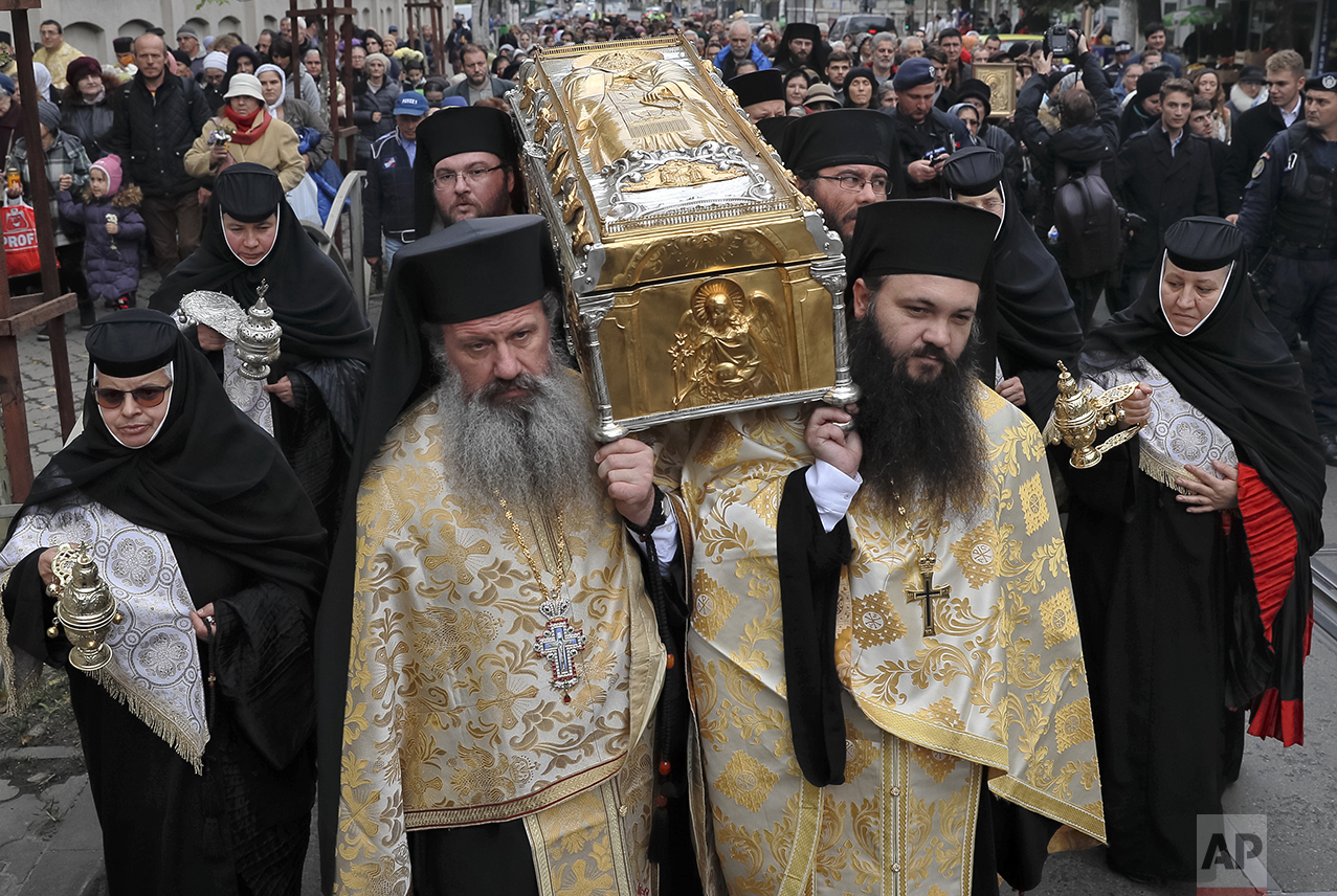  In this Saturday, Oct. 22, 2016 picture, priests carry the remains of Saint Dimitrie Bassarabov, during a pilgrimage, in Bucharest, Romania. The Romanian Orthodox and Catholic churches staged pilgrimages parading holy remains. The Catholics have a f
