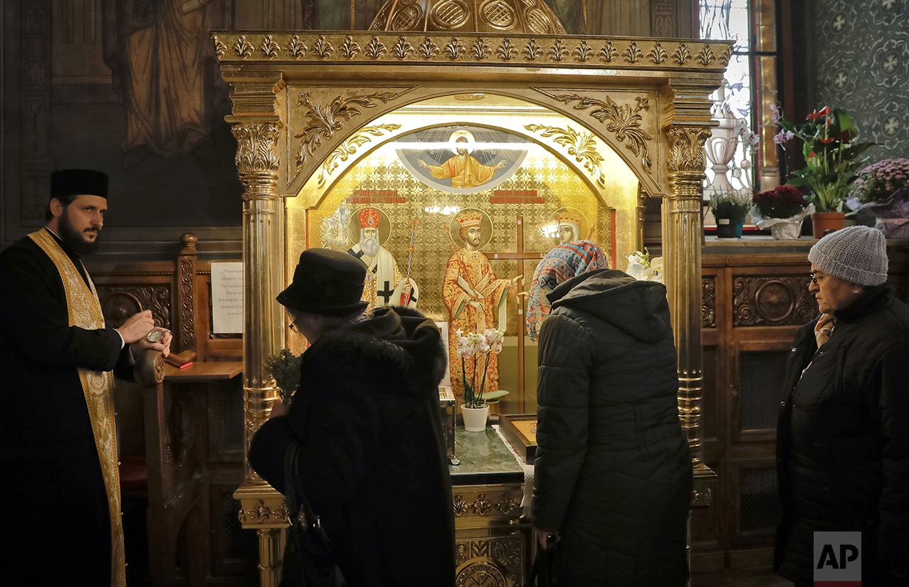  In this Saturday, Oct. 22, 2016 picture, women pass by a container holding remains of Saint Dimitrie Bassarabov, before they are taken out for a pilgrimage, at the orthodox patriarchal cathedral in Bucharest, Romania. (AP Photo/Vadim Ghirda) 