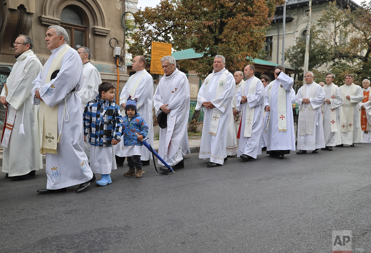  In this Sunday, Oct. 23, 2016 picture, Catholic priests march with remains of Pope John Paul II during a pilgrimage, in Bucharest, Romania. The Romanian Orthodox and Catholic churches staged pilgrimages parading holy remains. Both churches parade ho