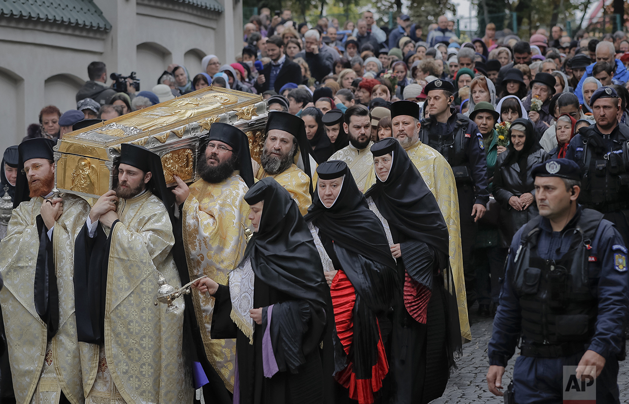  In this Saturday, Oct. 22, 2016 picture, priests carry the remains of Saint Dimitrie Bassarabov, during a pilgrimage, in Bucharest, Romania. (AP Photo/Vadim Ghirda) 