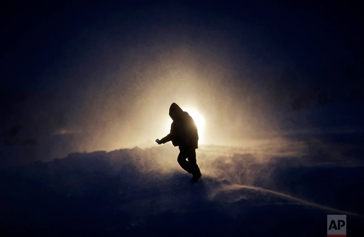 In this Tuesday, Nov. 29, 2016, photo, a person walks through a snow storm at the Oceti Sakowin camp where people have gathered to protest the Dakota Access oil pipeline in Cannon Ball, N.D. Those in the camp have shrugged off the heavy snow, icy winds and frigid temperatures. But if they defy next week's government deadline to abandon the camp, demonstrators know the real deep freeze lies ahead. (AP Photo/David Goldman)