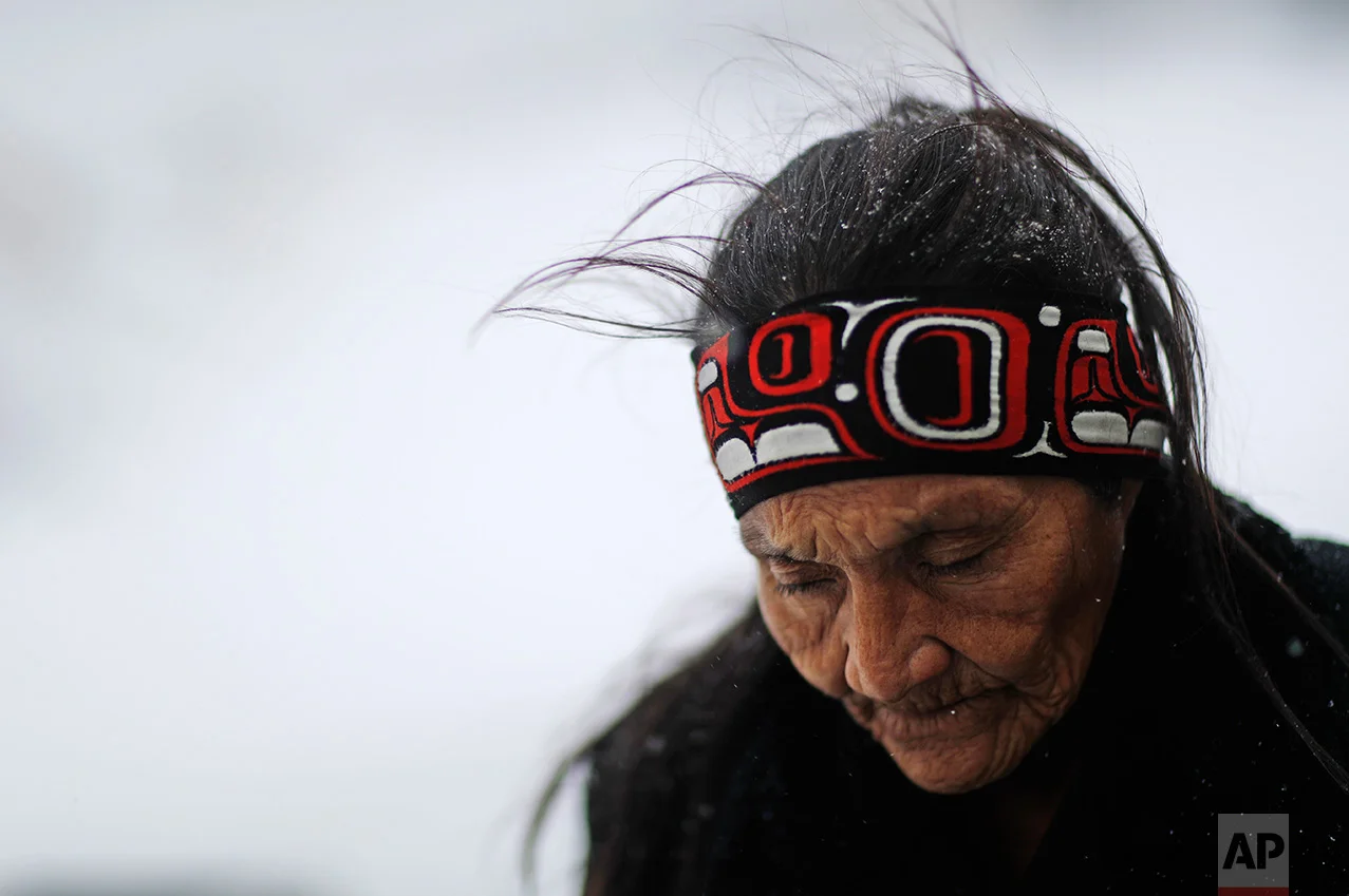 In this Tuesday, Nov. 29, 2016 photo, Grandma Redfeather of the Sioux Native American tribe walks in the snow to get water at the Oceti Sakowin camp where people have gathered to protest the Dakota Access oil pipeline in Cannon Ball, N.D. "It's for my people to live and so that the next seven generations can live also," said Redfeather of why she came to the camp. "I think about my grandchildren and what it will be like for them." (AP Photo/David Goldman)