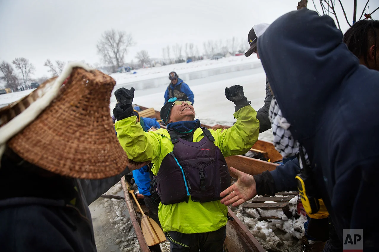 In this Thursday, Dec. 1, 2016 photo, Patty Sam Porter of Colville, Wash., and a member of the Colville Native American tribe, celebrates upon reaching shore by canoe at the Oceti Sakowin camp where people have gathered to protest the Dakota Access oil pipeline in Cannon Ball, N.D. Porter traveled from Montana with fellow tribal members on canoe for 10 days down the Missouri river to reach the camp. (AP Photo/David Goldman)