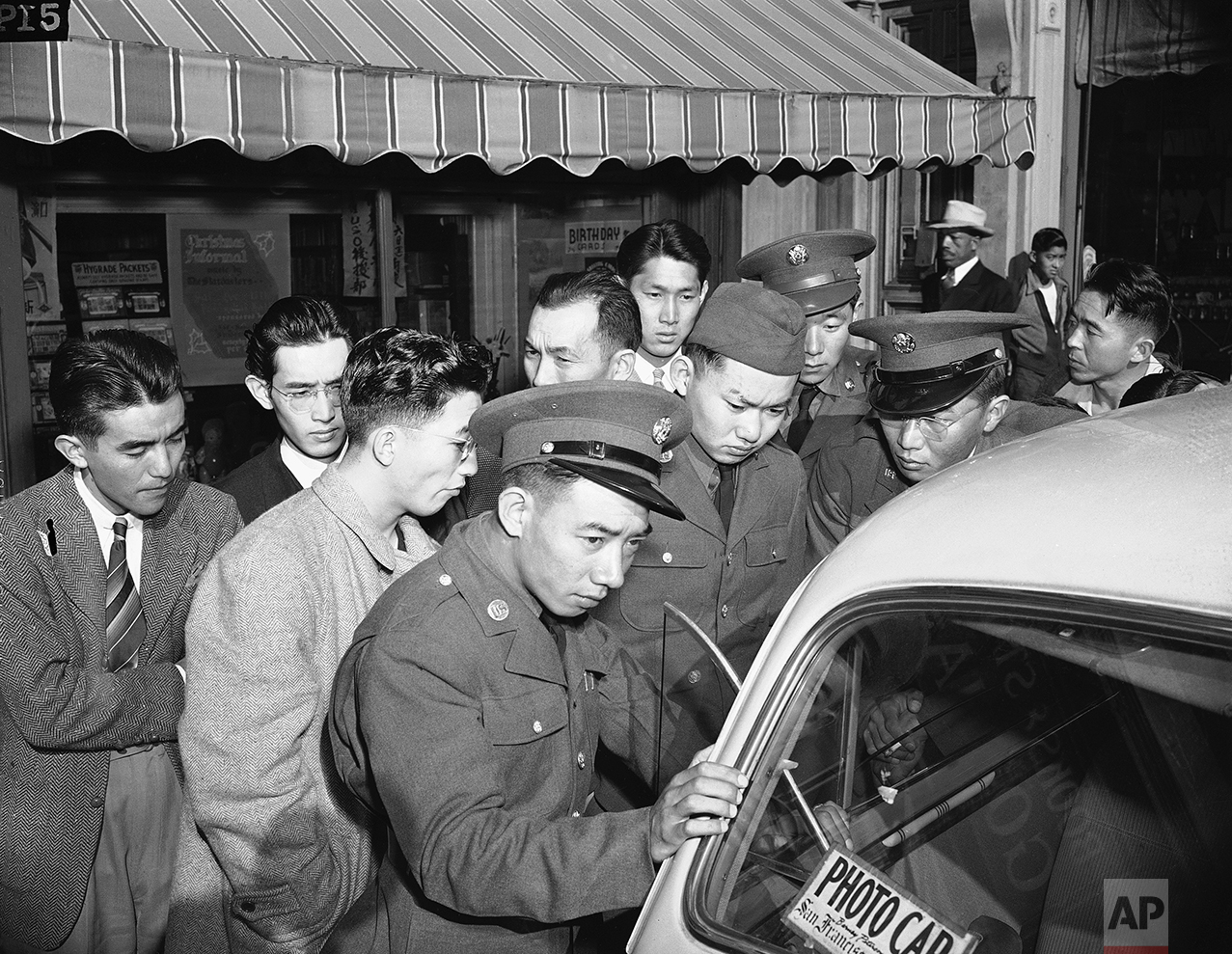 Young Japanese Americans, including several Army selectees, gather around a reporter's car in the Japanese section of San Francisco, Dec. 8, 1941. (AP Photo)